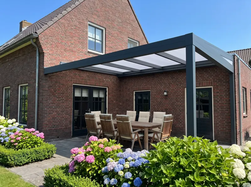 Antraciet aluminium terrasoverkapping aan een bakstenen woning