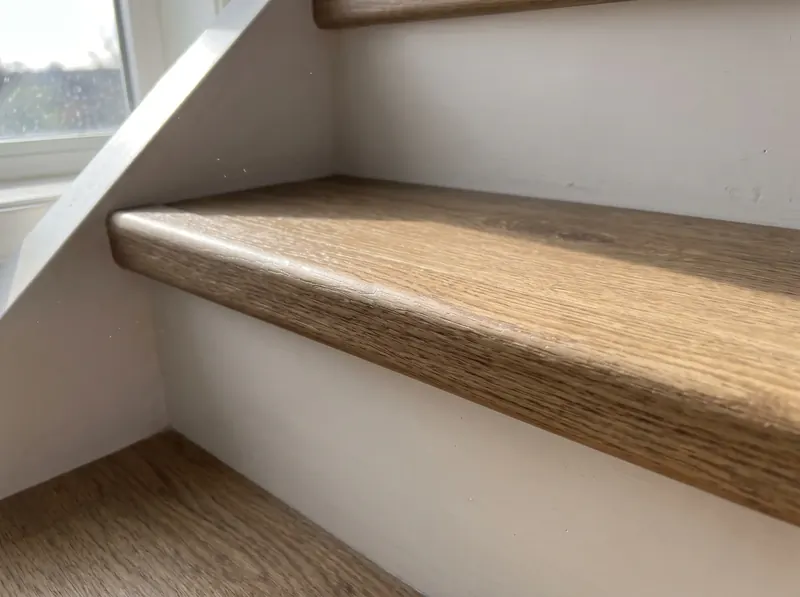 Traptrede in houtlook met wit stootbord van dichtbij
