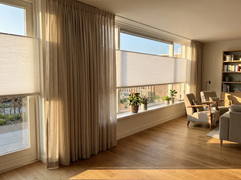 Woonkamer met nieuwe gordijnen en plissés na de montage